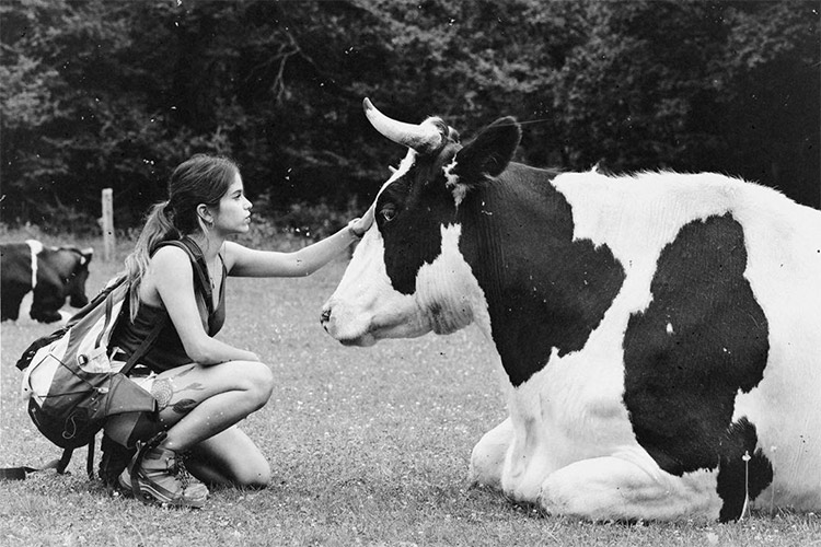 La influencer Jenny Rodríguez posando con ropa vegana, acariciando a una vaca.