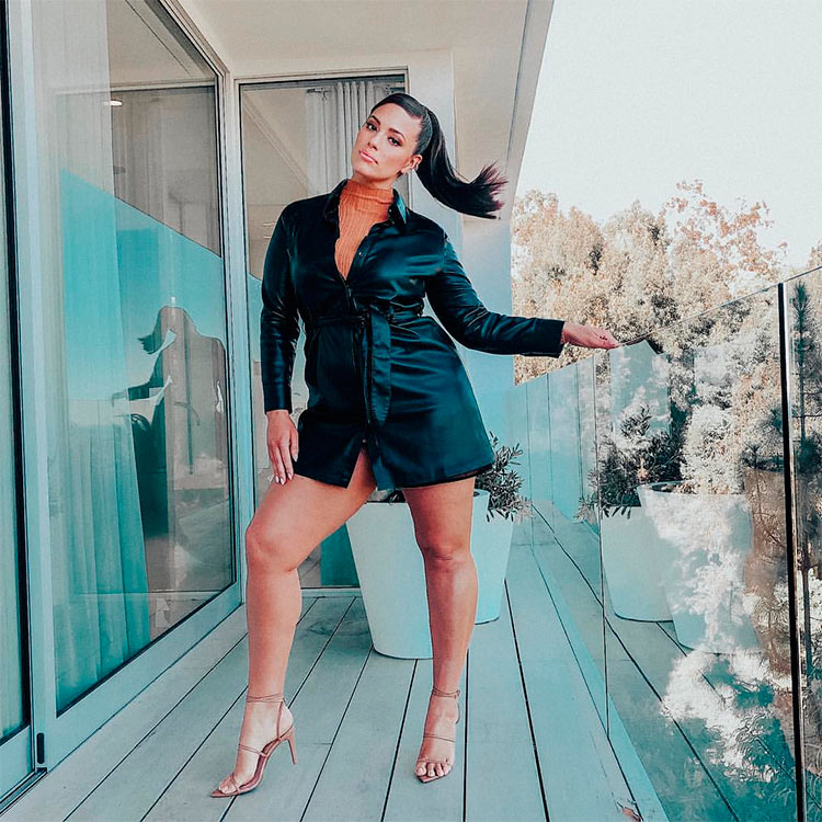 Aparece una de las más famosas modelos en Instagram, Ashley Graham posando con una chaqueta-vestido negra y un jersey de cuello alto, calzada con unas sandalias de tiras. 