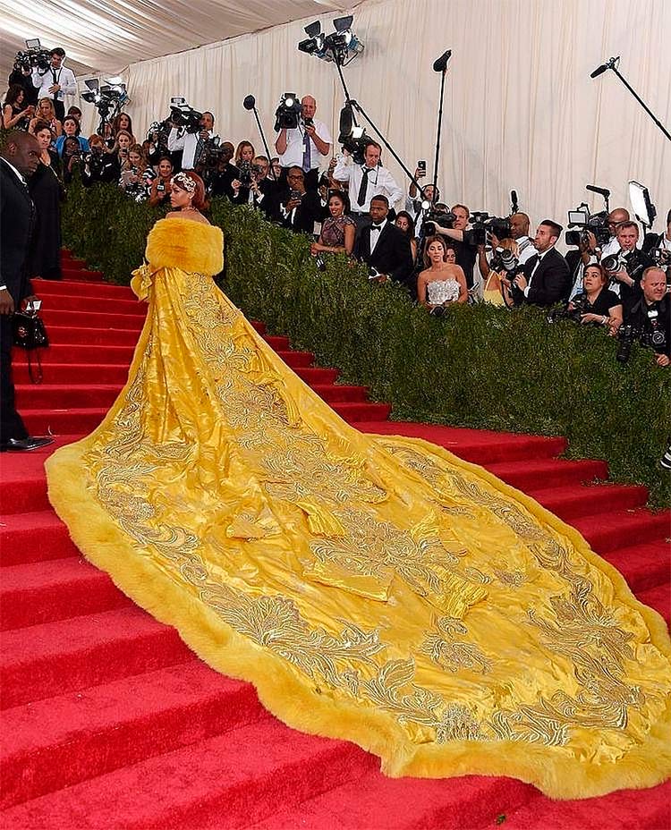 Rihanna subiendo las escaleras del museo MEt de Nueva York con su vestido-capa amarillo y siendo fotografiada por todos los paparazzi, el momento más icónico de la moda en los últimos años.