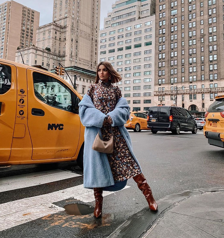 Alexandra Pereira posa para una foto de su Instagram en Nueva York con ropa de invierno para mujer genial, un vestido con botas y un abrigo tendencia azul.