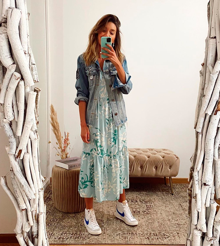 La influencer de moda @cristinacerqueiras se hace un selfie en un espejo en el que se la ve vestida con un vestido maxi floral que acompaña con unas zapatillas blancas mujer Nike