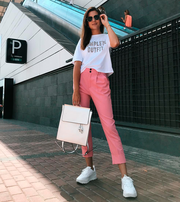 La influencer de moda Marianela luce un primaveral look con camiseta blanca y pantalón rosa, bolso blanco a juego con unas deportivas blancas mujer
