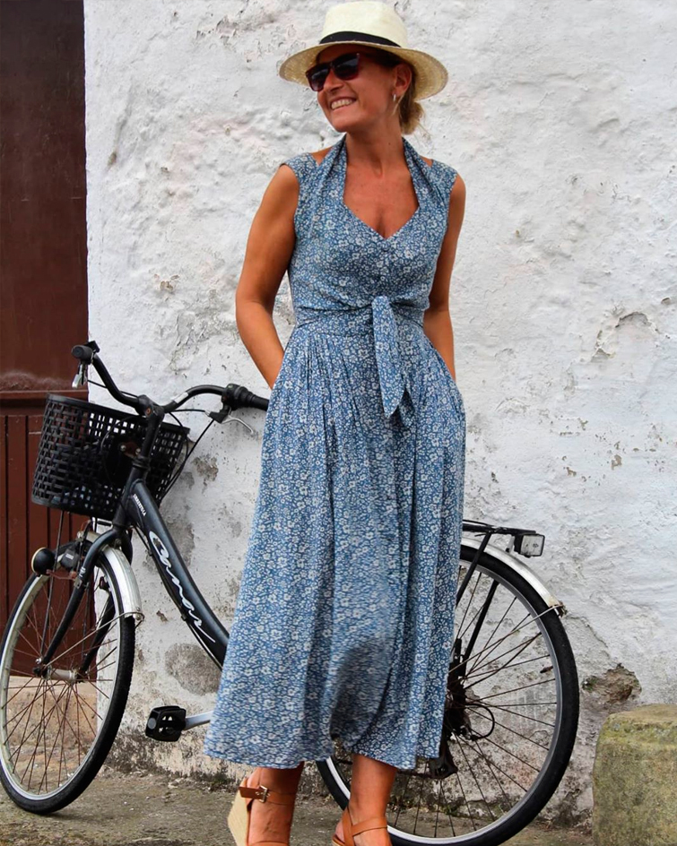 La influencer @elrincondenagore posa delante de una bicicleta con un vestido estampado de flores
