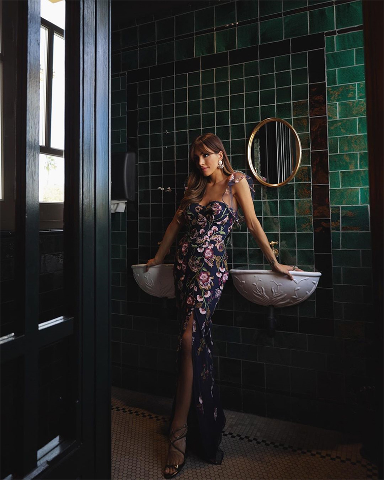 La influencer de moda Rocío Osorno luce un maxivestido floreado en un baño de colores oscuros