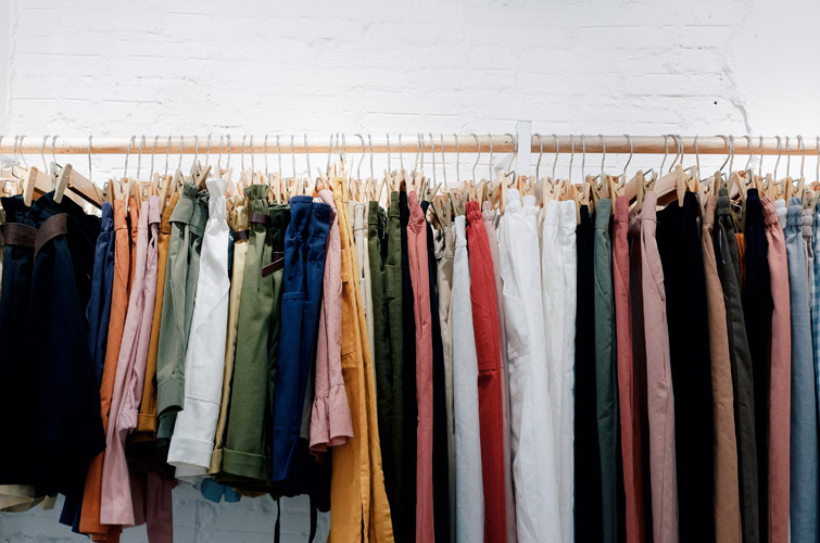 Pantalones almacenados y colgados en perchas, dentro de una de las tiendas que compren ropa de segunda mano en bilbao